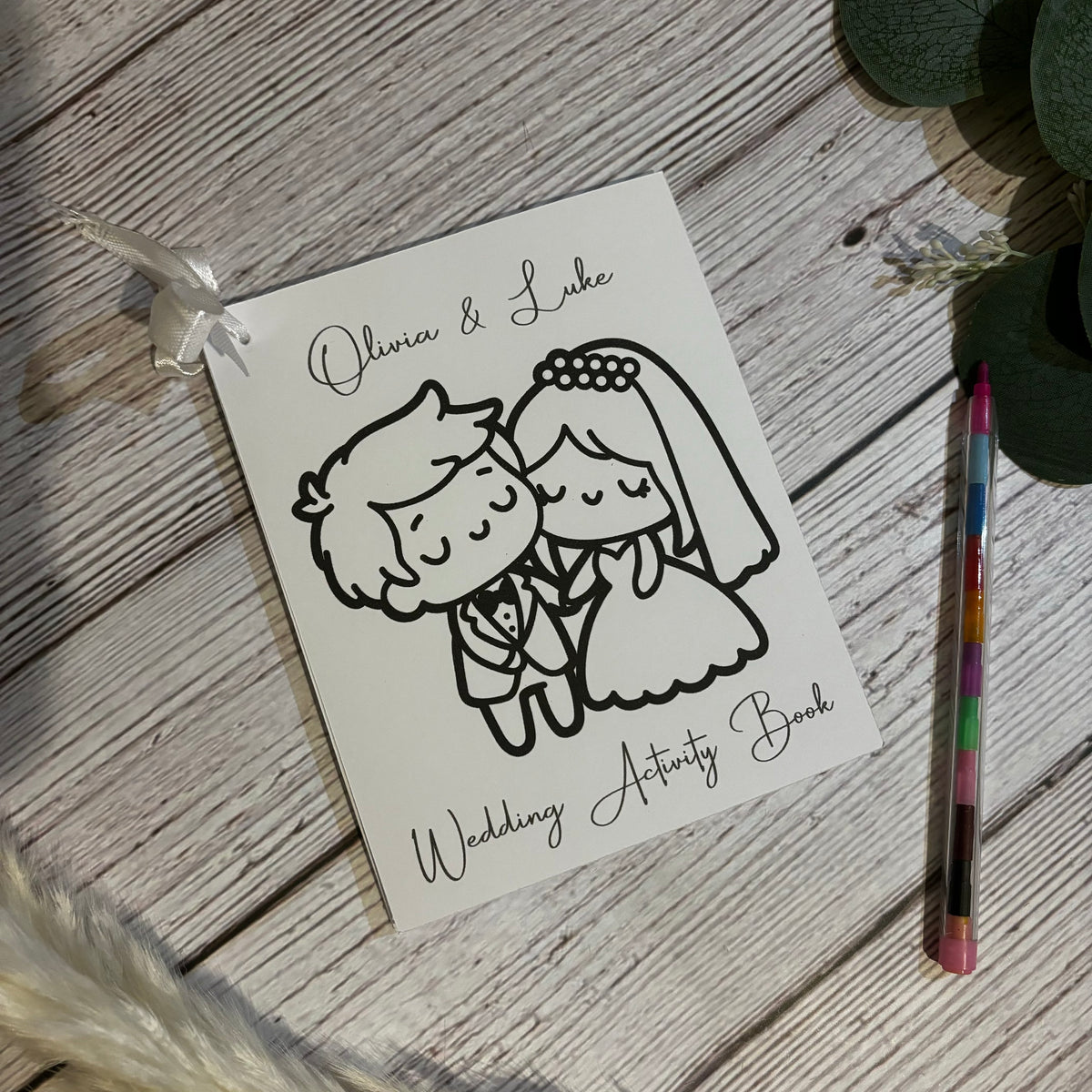 Personalised wedding activity book for children with ribbon and multicoloured stackable crayon